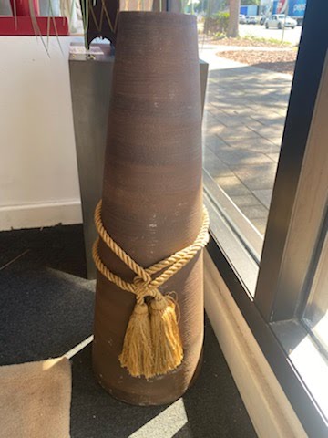 Brown clay vase with gold rope